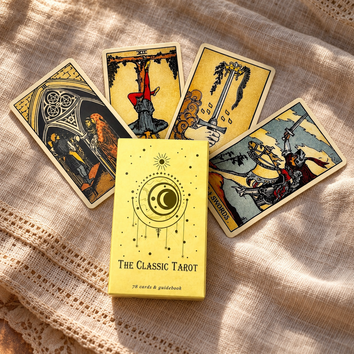 A tarot card deck box labeled 'The Classic Tarot' sits on a beige linen cloth with four illustrated tarot cards fanned behind it.