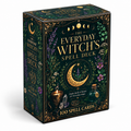 The Everyday Witch's Spell Deck box, featuring a dark green background decorated with gold ornate borders, purple and white flowers, a crescent moon, and a small cauldron and potion bottle illustration.