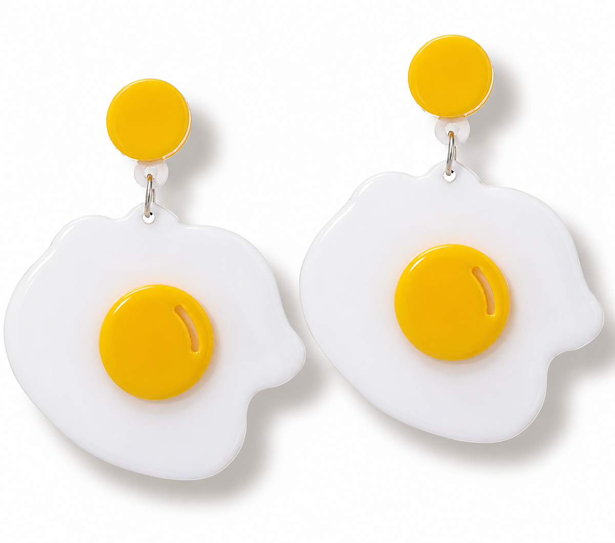 A pair of novelty egg-shaped drop earrings with bright yellow circular studs and centers on a clean white background.