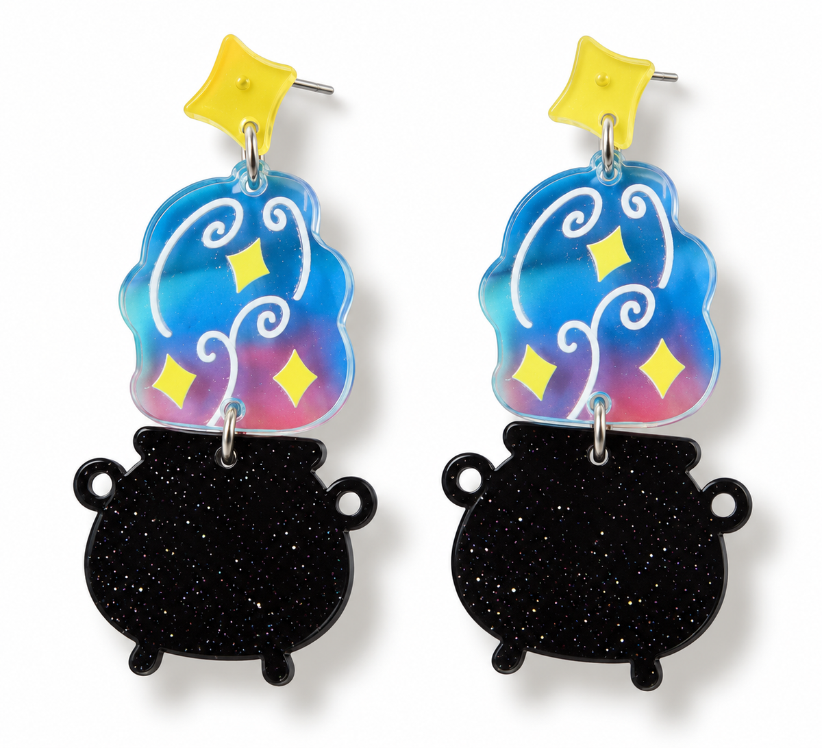 A pair of dangle earrings featuring black glitter cauldron charms and holographic blue, pink, and yellow star-shaped charms on silver posts with yellow star studs, shown against a plain white background.