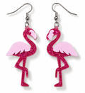 A pair of dangling earrings shaped like flamingos, with bright pink glitter bodies and pale pink wings, hanging from silver fishhook wires on a white background.