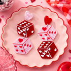 Heart Dice Earrings with pink and glitter red dice, heart-shaped pips and red and pink heart studs on a pink plate with a red scalloped edge and glitter ball