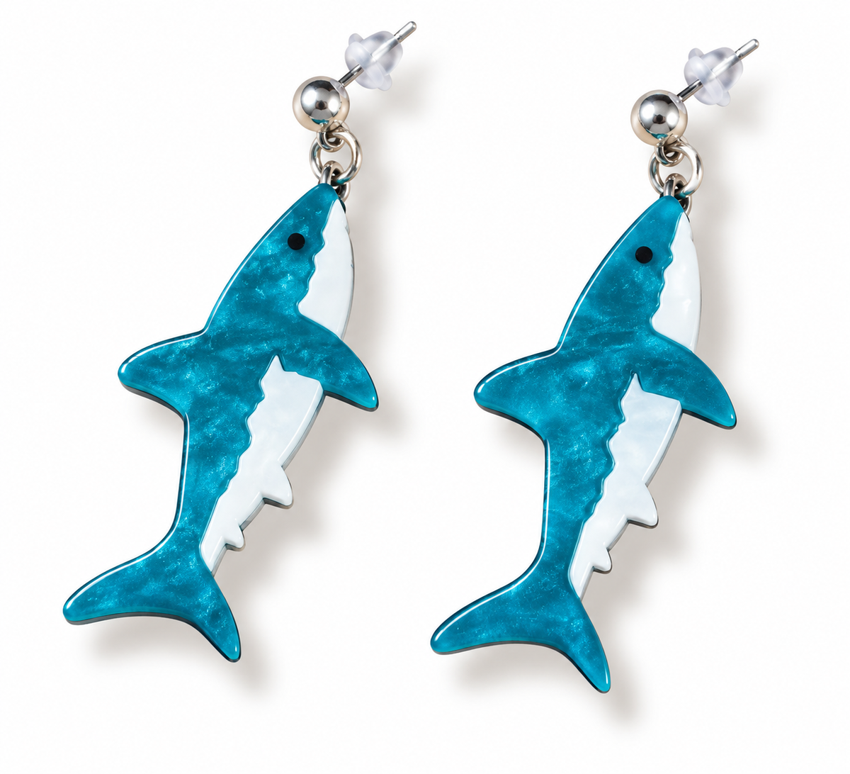 A pair of shark-shaped drop earrings with a textured turquoise blue and white enamel design, attached to silver stud posts on a white background.
