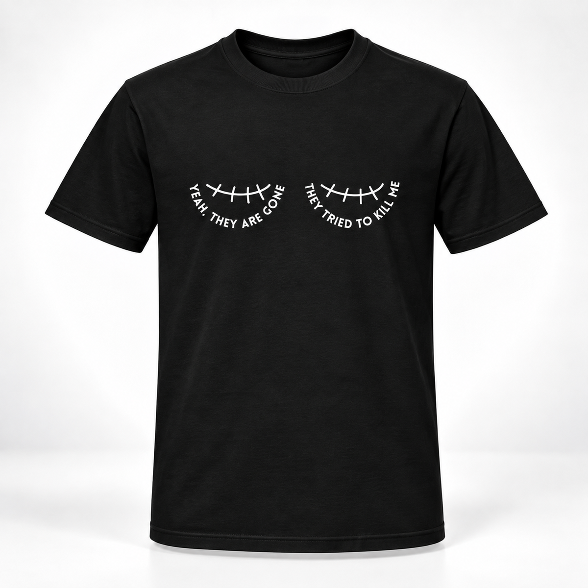 A black short-sleeve crewneck t-shirt with a white graphic of a double mastectomy scar and the text 'YEAH THEY ARE GONE' and 'THEY TRIED TO KILL ME' printed on the chest.