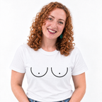 A smiling woman with curly red hair wearing a white crew-neck t-shirt with a minimalist black graphic of two breasts, set against a plain white background.
