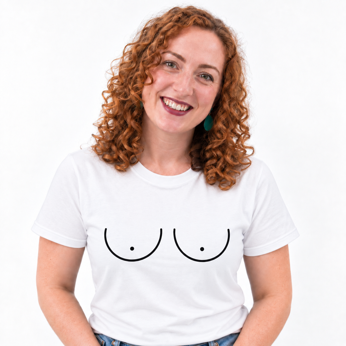 A smiling woman with curly red hair wearing a white crew-neck t-shirt with a minimalist black graphic of two breasts, set against a plain white background.