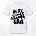 A white short-sleeve crewneck t-shirt with a bold black retro-style graphic on the front that reads 'IN MY CANCER WARRIOR ERA' surrounded by small star accents.