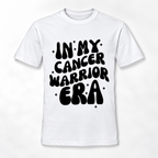 A white short-sleeve crewneck t-shirt with a bold black retro-style graphic on the front that reads 'IN MY CANCER WARRIOR ERA' surrounded by small star accents.